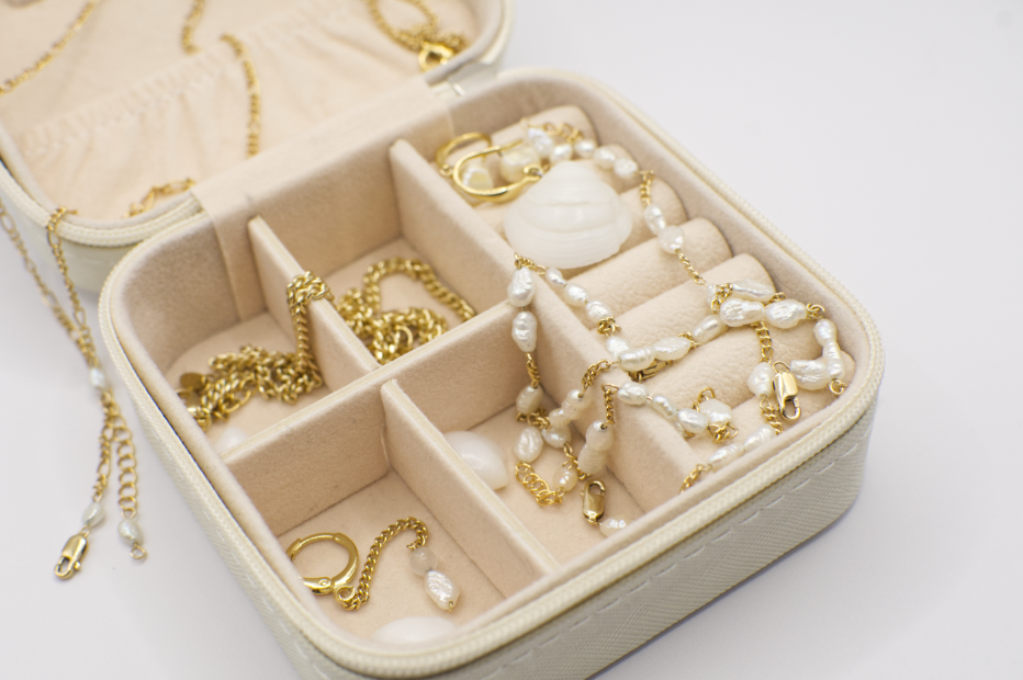 GEOLOVERS jewelry box filled with golden jewelry, loose shells and freshwater pearls. 